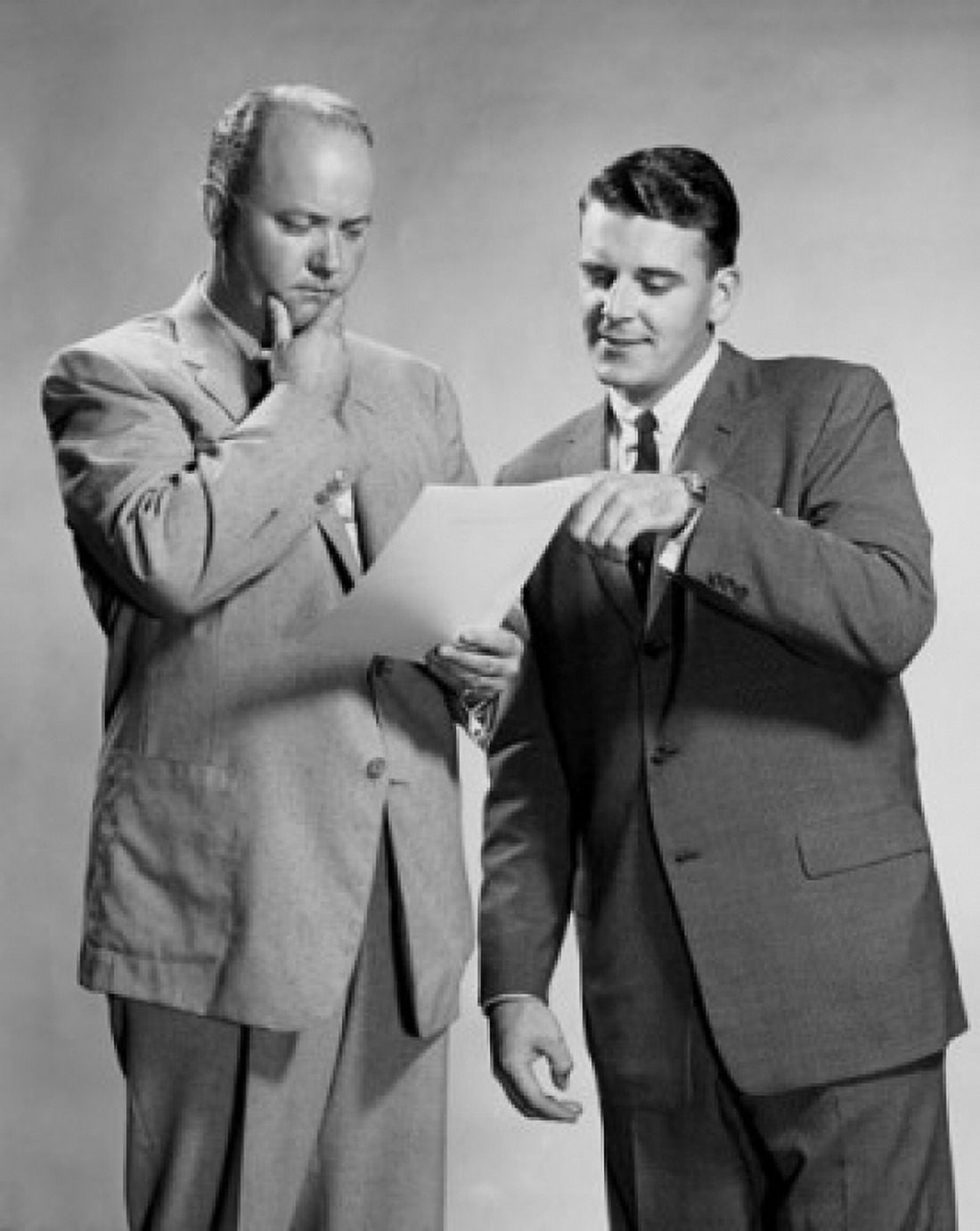 Two businessmen standing discussing document Canvas Art - (24 x 36)