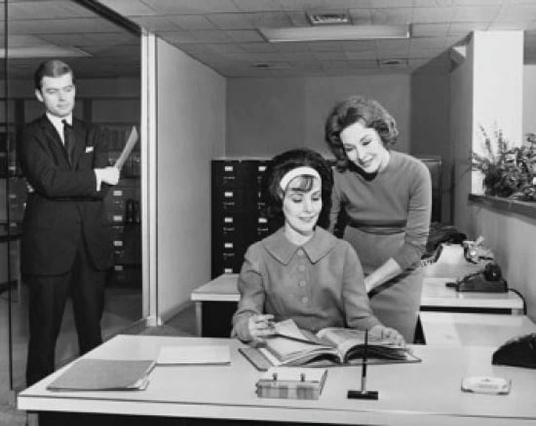 Two businesswomen reading a file and a businessman standing at the door of an office Canvas Art - (24 x 36)