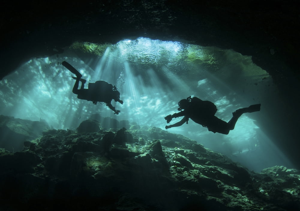 Two divers silhouetted in light at entrance to Chac Mool cenote Mexico Canvas Art - Karen DoodyStocktrek Images (17 x 12)