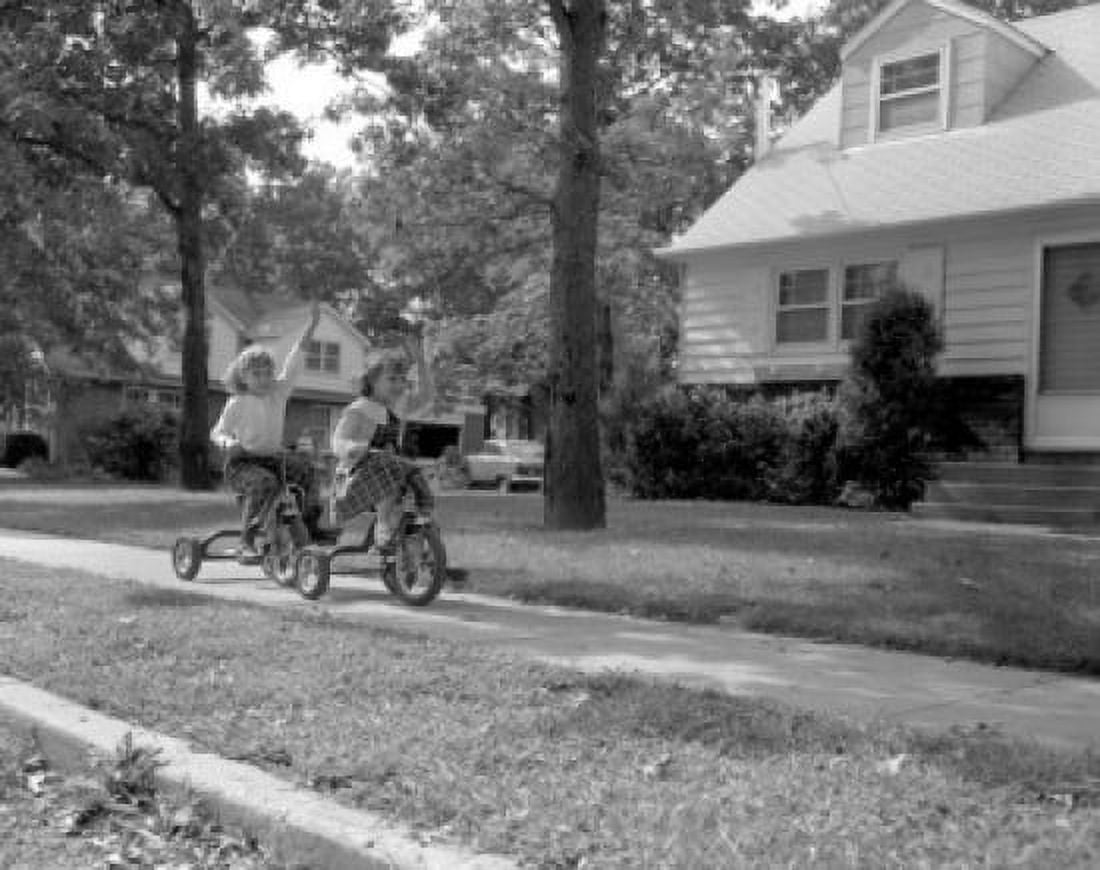 Two girls cycling in front of house Canvas Art - (18 x 24)