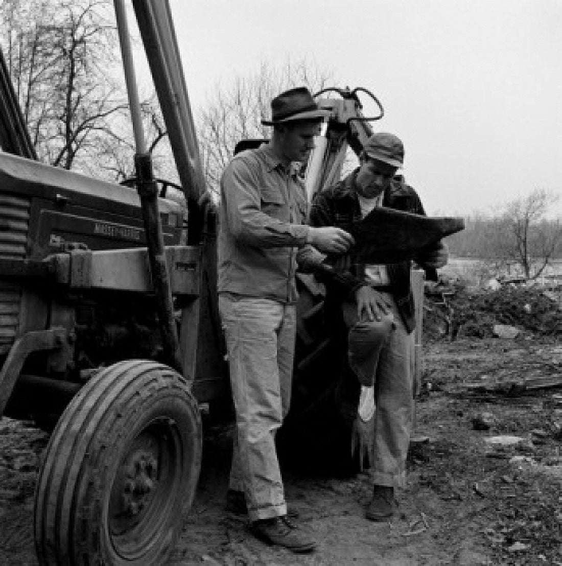 Two men standing by tractor discussing plans Canvas Art - (18 x 24)