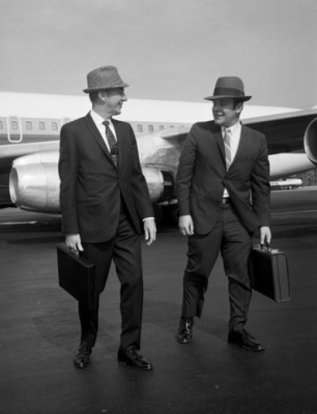 Two men walking along airplane at airport Canvas Art - (18 x 24)