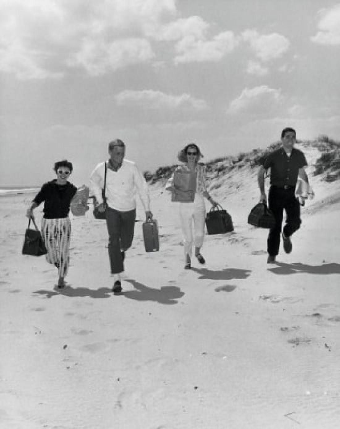 Two mid adult couples holding bags and running on the beach Canvas Art - (18 x 24)