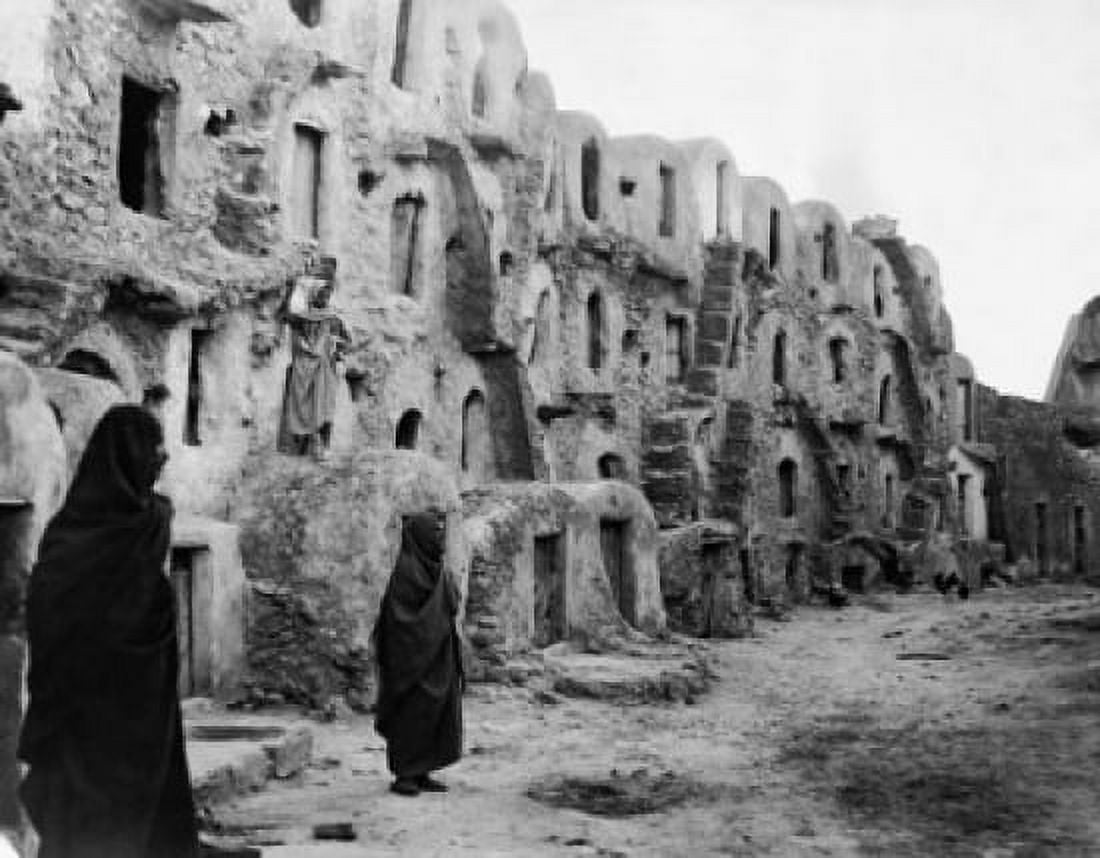 Two people standing in front of cave homes Medenine Tunisia Canvas Art - (24 x 36)