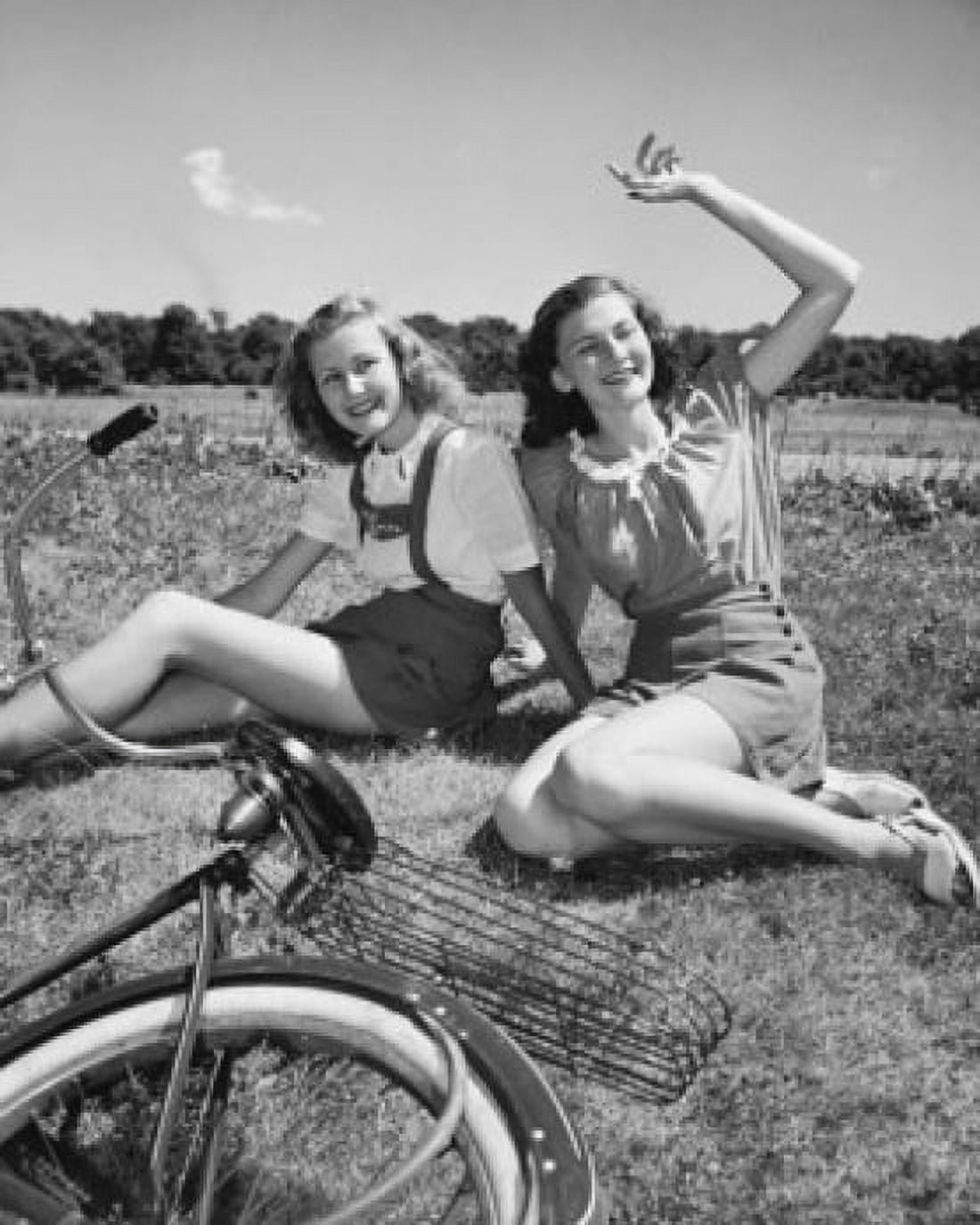 Two teenage girls sitting on grass and smiling Canvas Art - (24 x 36)