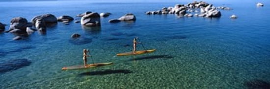Two women paddle boarding in a lake Lake Tahoe California USA Canvas Art - Panoramic Images (36 x 12)