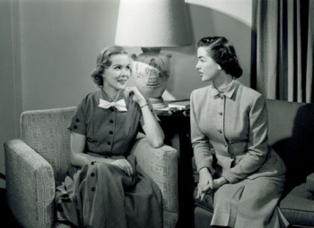 Two women talking in living room Canvas Art - (24 x 36)