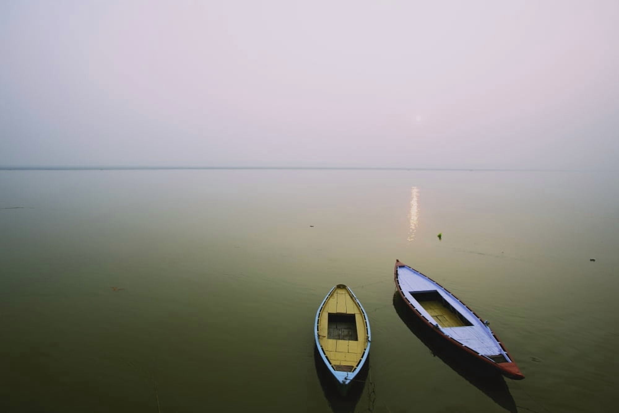 Two wooden boats sit on the tranquil water of the Ganges Varanasi India Canvas Art - Chris Caldicott Design Pics (19 x 12)