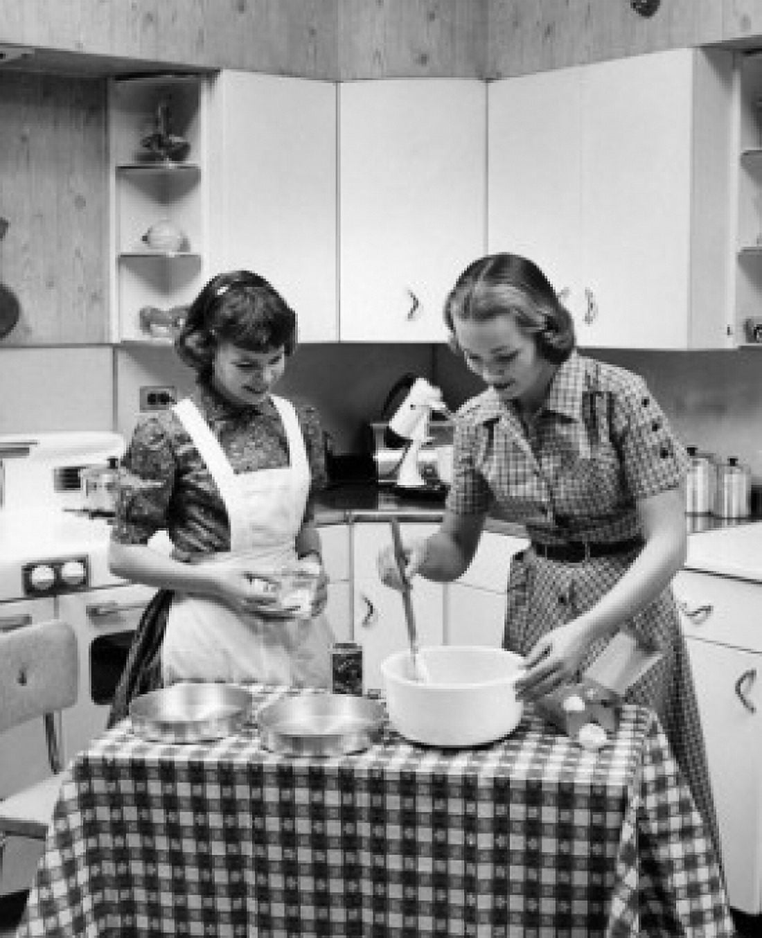 Two young women cooking Canvas Art - (24 x 36)