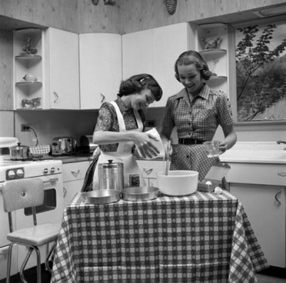 Two young women cooking Canvas Art - (24 x 36)