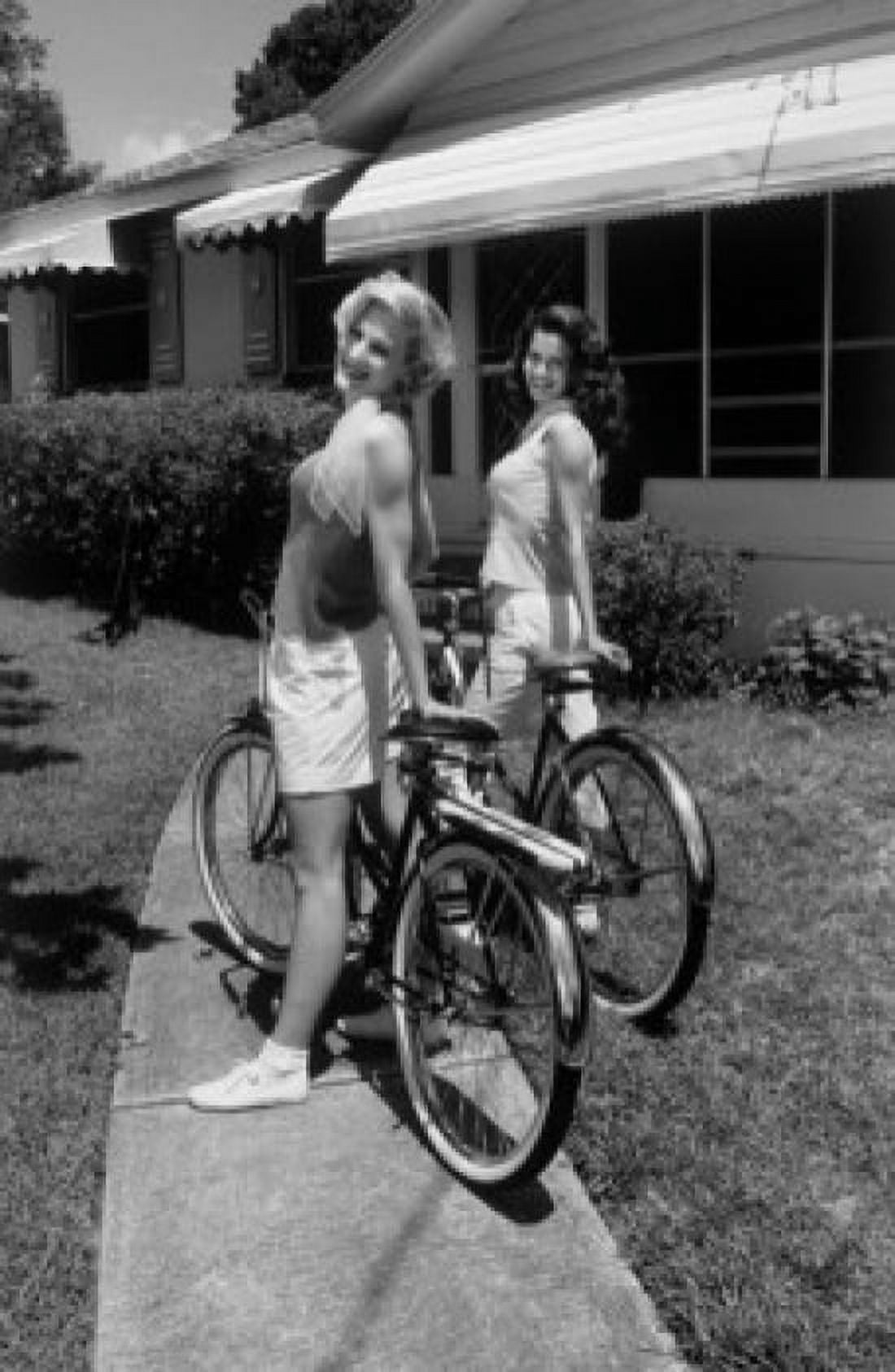 Two young women standing with bicycles in front yard Canvas Art - (24 x 36)