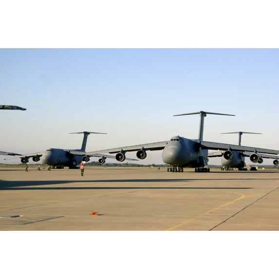 An U.S. Airman Dwarfed By A C-5 Galaxy Cargo Aircraft Signals The Plane Through A Crowded Runway At Moron Air Base Spain. The Planes Were Carrying Supplies And Soldiers To Afghanistan On Nov. 28 2001.