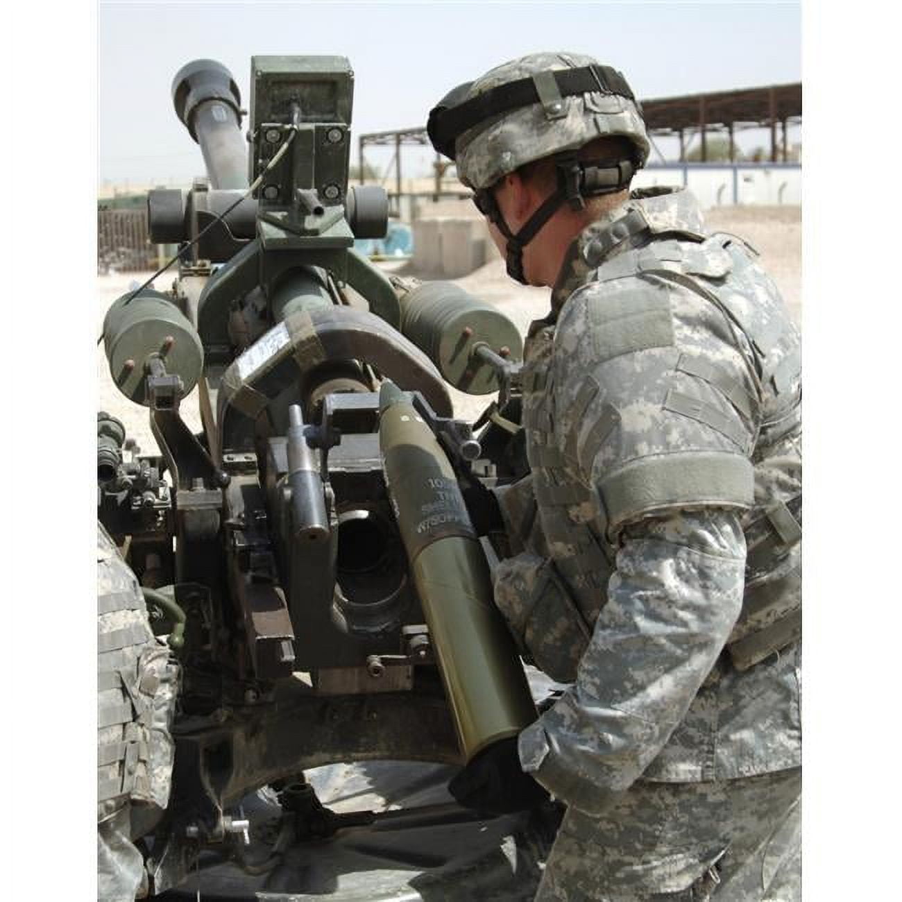 U.S. Army Soldier Loads A 105mm Artillery Round Into A M119 Howitzer
