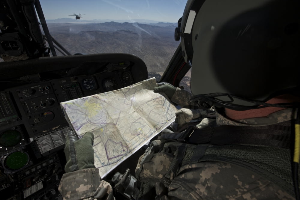 UH-60 Black Hawk pilot reading a map while in flight to New Mexico Canvas Art - Terry MooreStocktrek Images (35 x 23)
