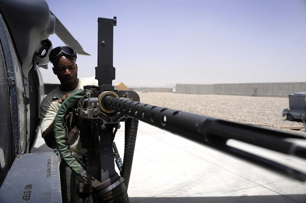 US Air Force Airman performing routine maintenance on the 50 caliber machine gun of an HH-60G Pave Hawk Canvas Art - Stocktrek Images (34 x 23)