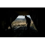 US Air Force Airman pushes out pallets from a C-130H Hercules Poster Print by Stocktrek Images (17 x 11)