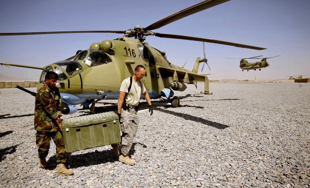 US Air Force soldier helps an Afghan airman carry ammunition to a Mi-35 Hip helicopter Canvas Art - Stocktrek Images (36 x 22)
