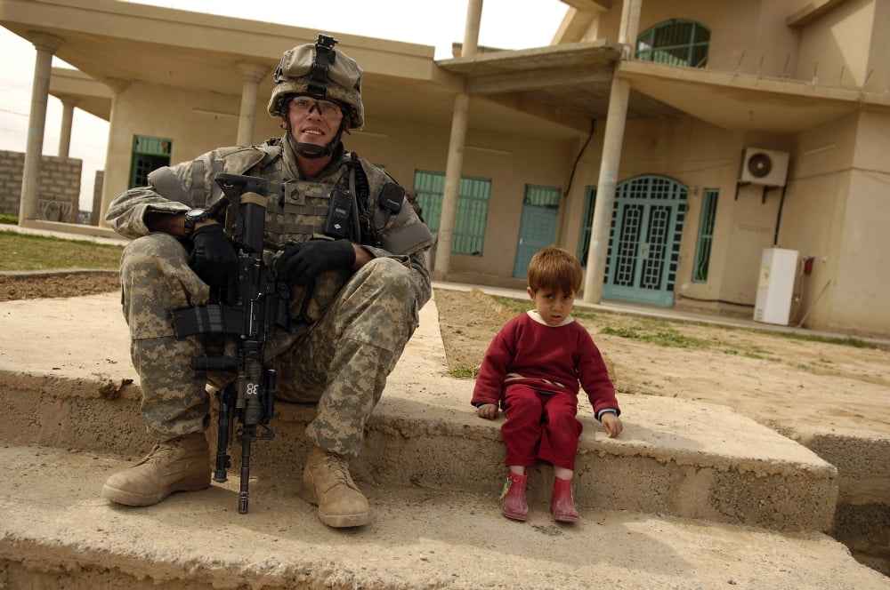 US Army Sergeant sits next to an Iraqi boy Canvas Art - Stocktrek Images (34 x 23)