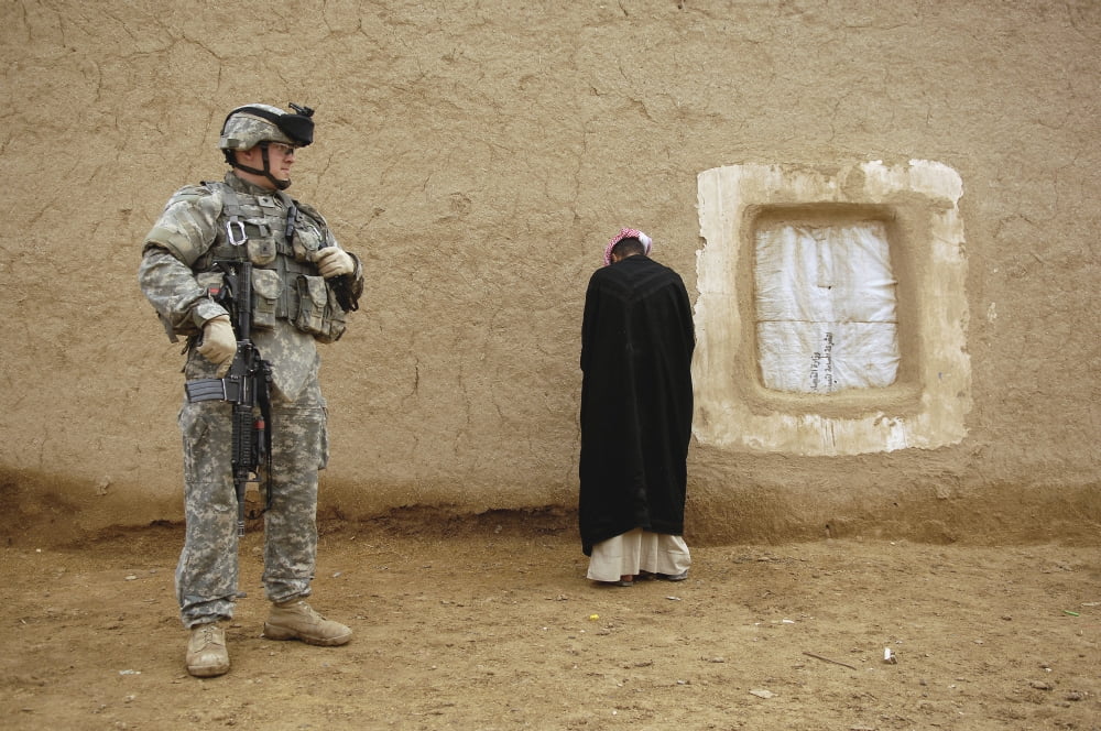 US Army Specialist guards an Iraqi villager Canvas Art - Stocktrek Images (34 x 23)