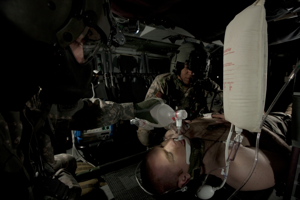US Army medics simulating ventilation of a mock patient aboard a UH-60 Blackhawk Canvas Art - Terry MooreStocktrek Images (18 x 12)
