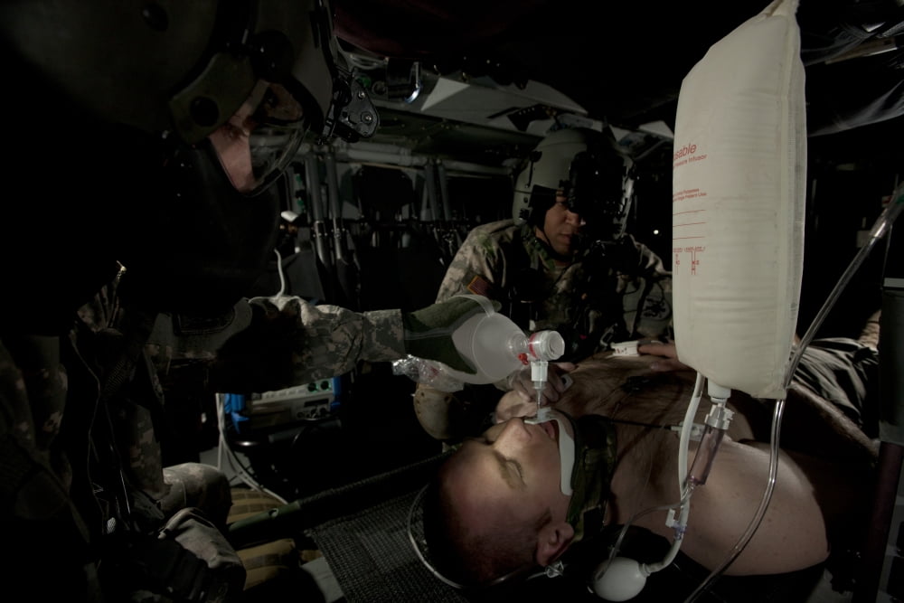 US Army medics simulating ventilation of a mock patient aboard a UH-60 Blackhawk Canvas Art - Terry MooreStocktrek Images (35 x 23)