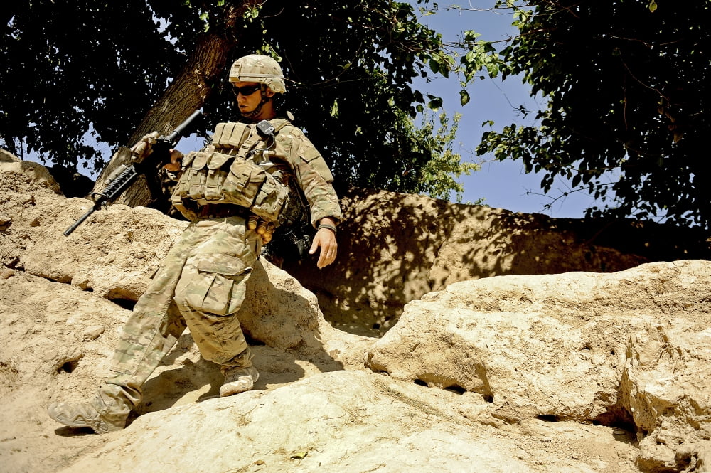 US Army soldier climbs down a hill during a patrol in a local Afghan village Canvas Art - Stocktrek Images (35 x 23)