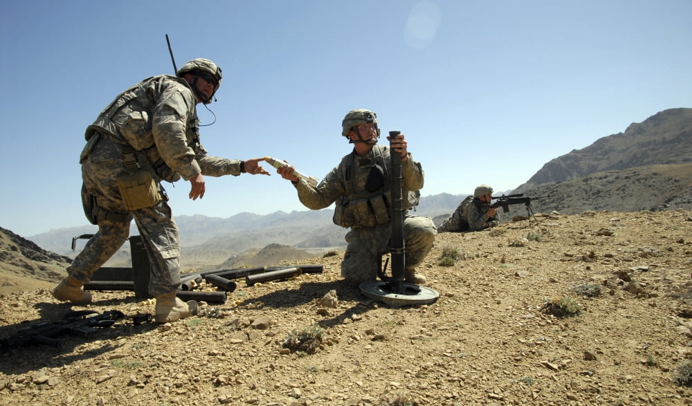 US Army soldier hands a 60 mm mortar round to a fellow soldier while providing fire support on enemy positions Canvas Art - Stocktrek Images (37 x 22)