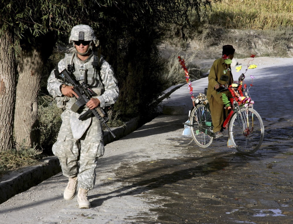 US Army soldier patrols through a village in Afghanistan Canvas Art - Stocktrek Images (33 x 25)