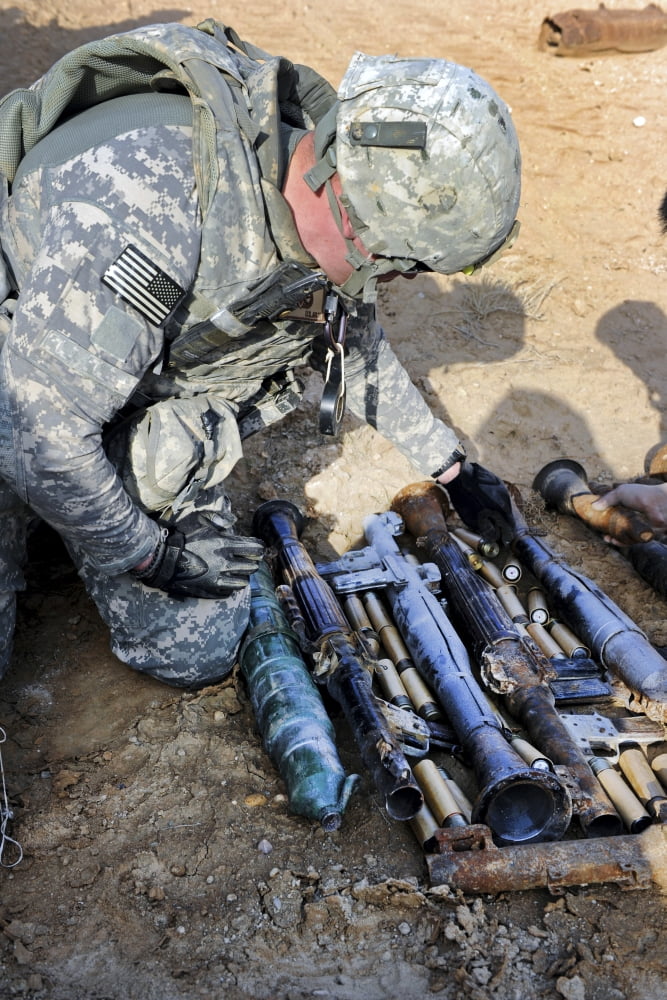 US Army soldier places unexploded ordnance into a pile for disposal Canvas Art - Stocktrek Images (23 x 34)
