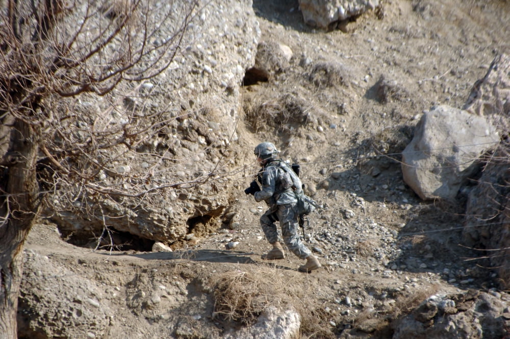 US Army soldier walks up the side of a hill to look at caves Canvas Art - Stocktrek Images (34 x 23)