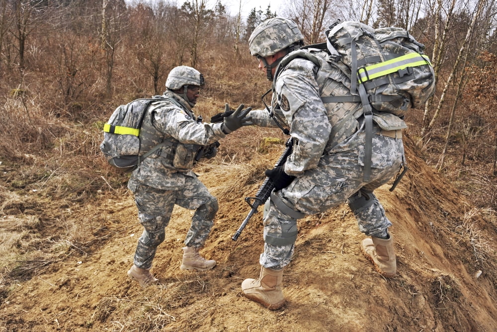 US Army soldiers helps a fellow soldier traverse rugged terrain Canvas Art - Stocktrek Images (35 x 23)