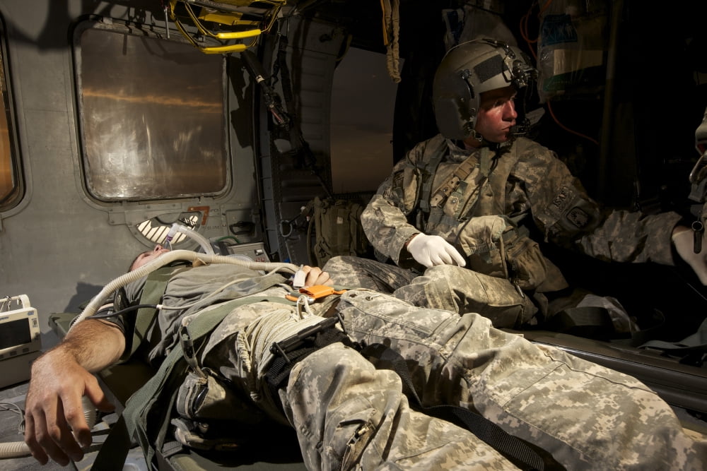 US Army specialist practices giving first aid to a wounded soldier Canvas Art - Terry MooreStocktrek Images (18 x 12)