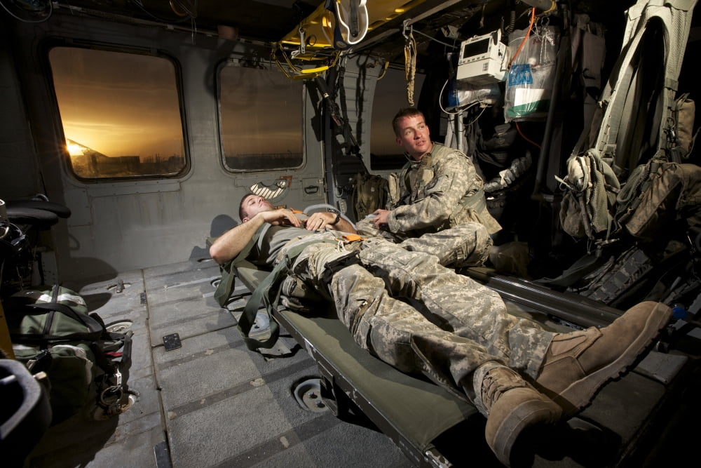 US Army specialist practices giving first aid to a wounded soldier Canvas Art - Terry MooreStocktrek Images (35 x 24)