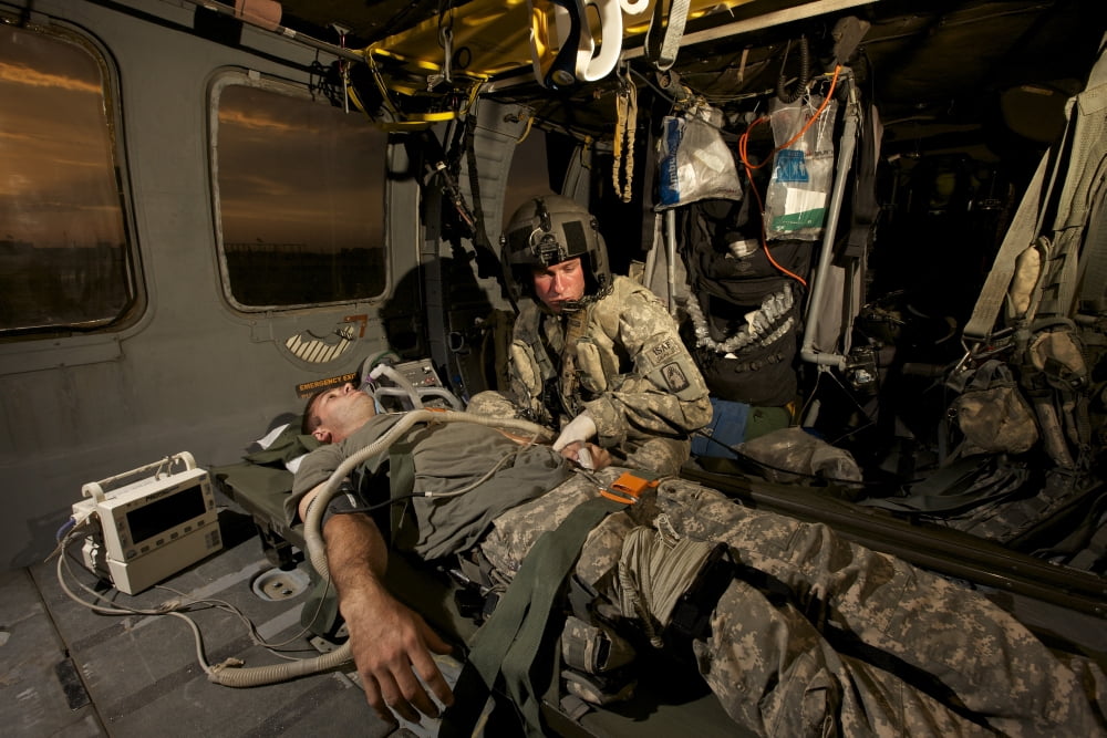 US Army specialist practices giving first aid to a wounded soldier Canvas Art - Terry MooreStocktrek Images (35 x 24)