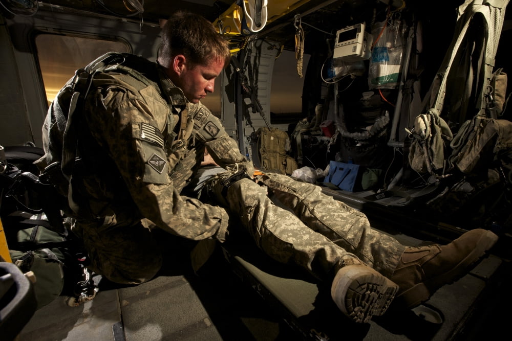 US Army specialist practices giving first aid to a wounded soldier Canvas Art - Terry MooreStocktrek Images (35 x 24)