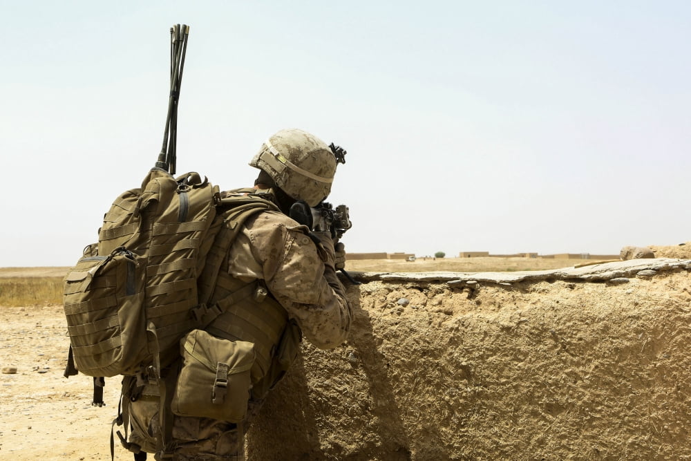 US Marine takes cover behind a wall during a patrol in Afghanistan Canvas Art - Stocktrek Images (34 x 23)
