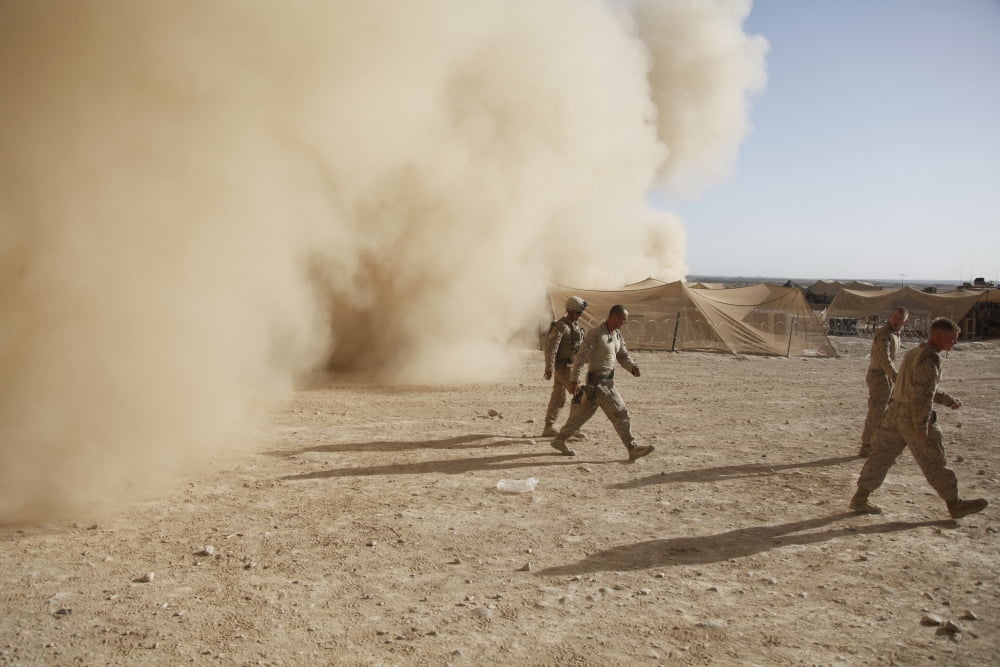 US Marines walk away from a dust cloud at a military base in Afghanistan Canvas Art - Stocktrek Images (35 x 23)