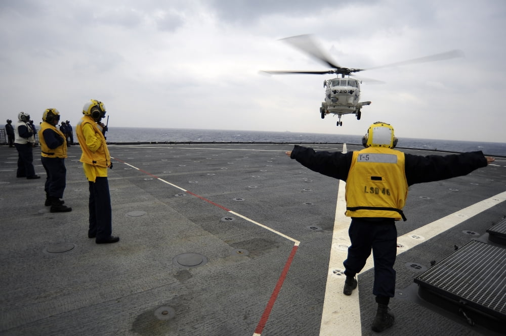 US Navy Boatswains Mate directs a H-60 helicopter on the flight deck of USS Tortuga Canvas Art - Stocktrek Images (34 x 23)