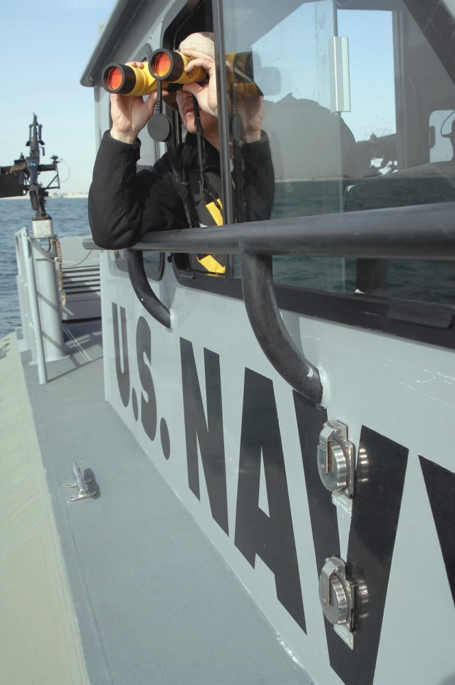 US Navy Boatswains Mate looks through binoculars as he patrols the coastal waters Canvas Art - Stocktrek Images (23 x 34)