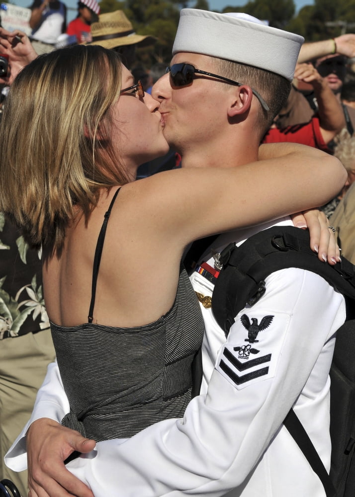 US Navy sailor is kissed by his wife after arriving at Naval Station North Island Canvas Art - Stocktrek Images (24 x 34)