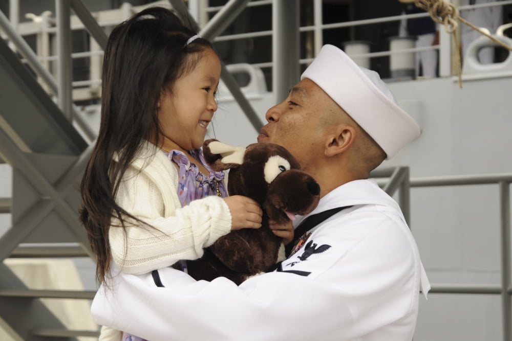 US Navy sailor receives a hug from his daughter during homecoming Canvas Art - Stocktrek Images (35 x 23)