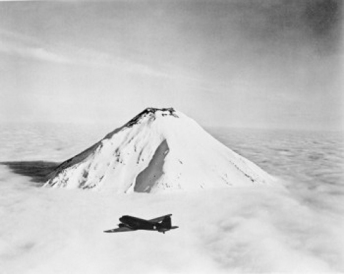 USA Aleutian Islands Naval Air Transport flying towards Attu above snow capped Caroloi volcano Canvas Art - (24 x 36)