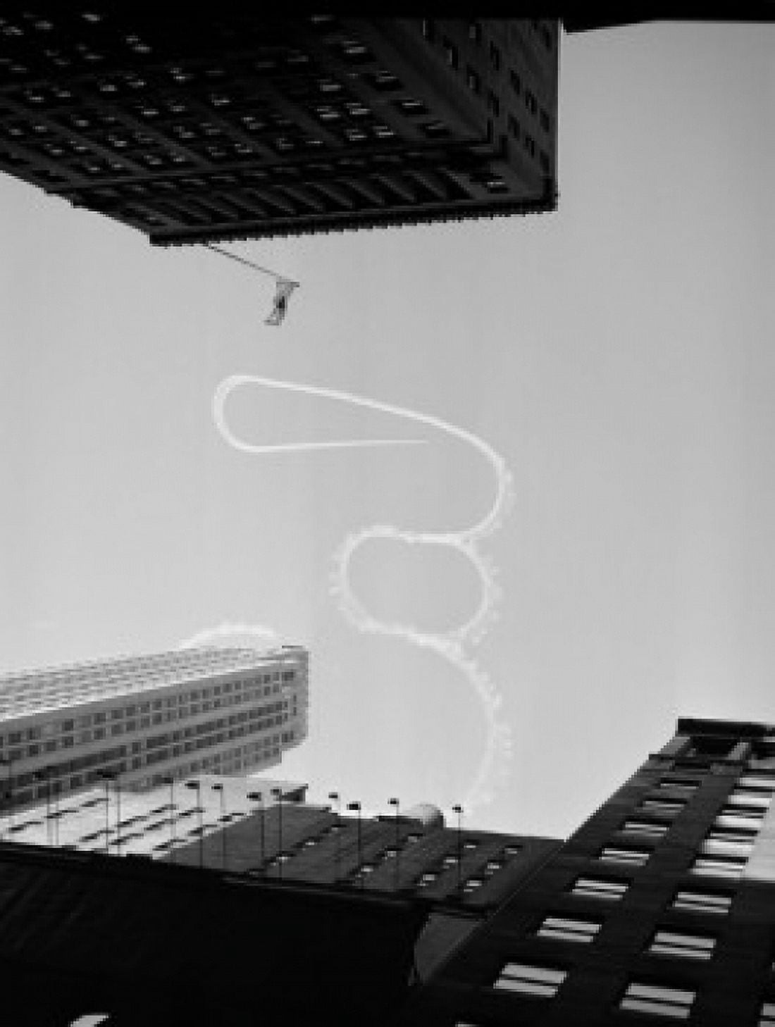 USA New York City Upward view of acrobatic aeroplane vapor trail over skyscrapers Canvas Art - (24 x 36)
