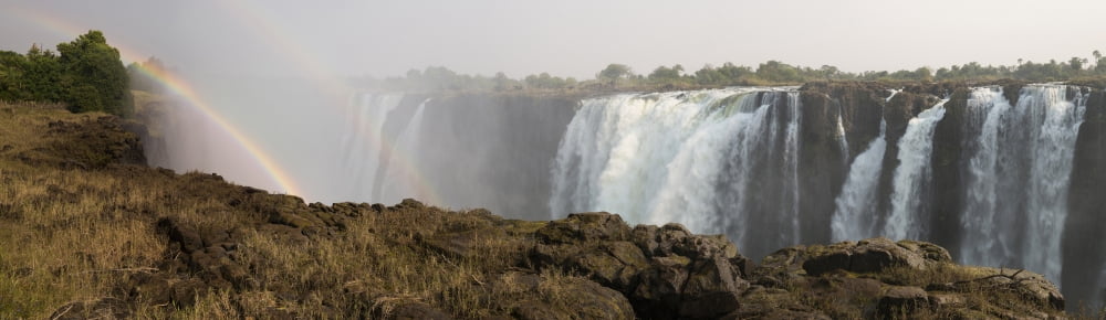 Victoria Falls with rainbow in the mist Zambezi River Zimbabwe Canvas Art - Panoramic Images (36 x 12)