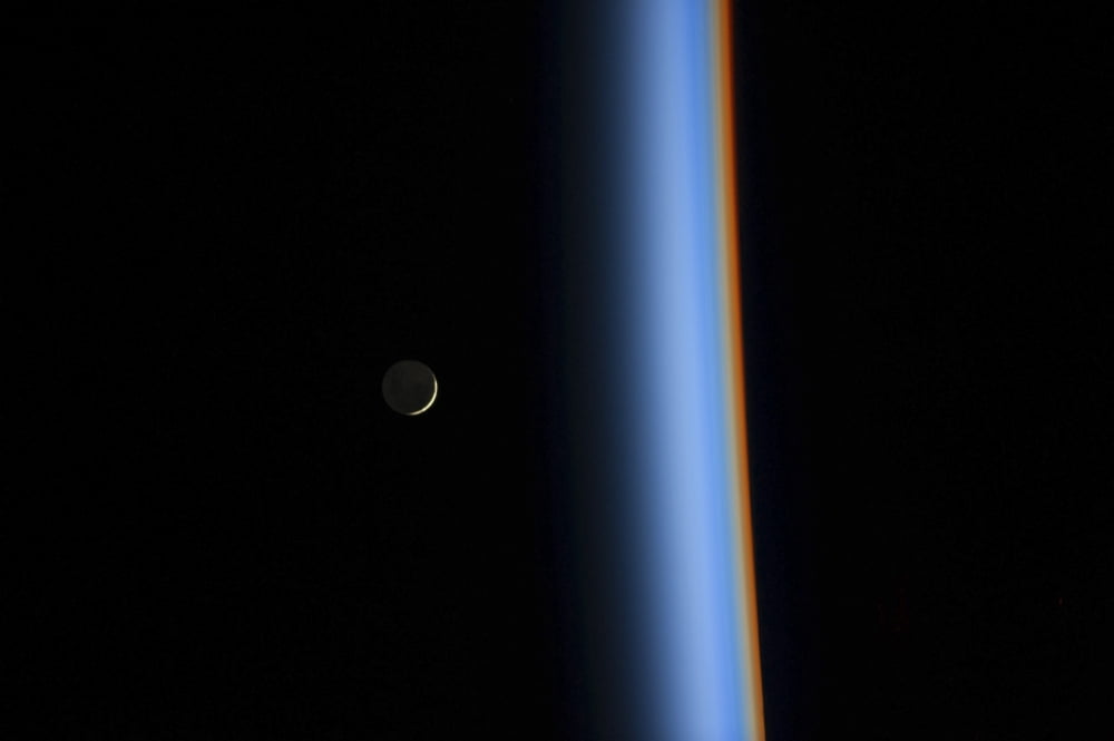 View of a crescent moon rising and the cusp of Earths atmosphere Canvas Art - Stocktrek Images (34 x 23)