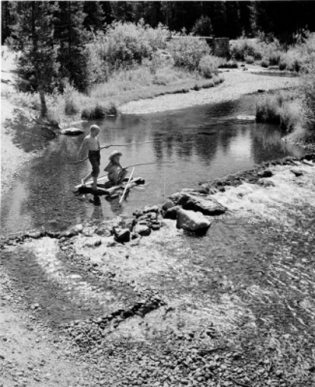 Vintage photograph of boy and girl on wooden raft fly-fishing with improvised fishing rods in stream Canvas Art - (24 x 36)