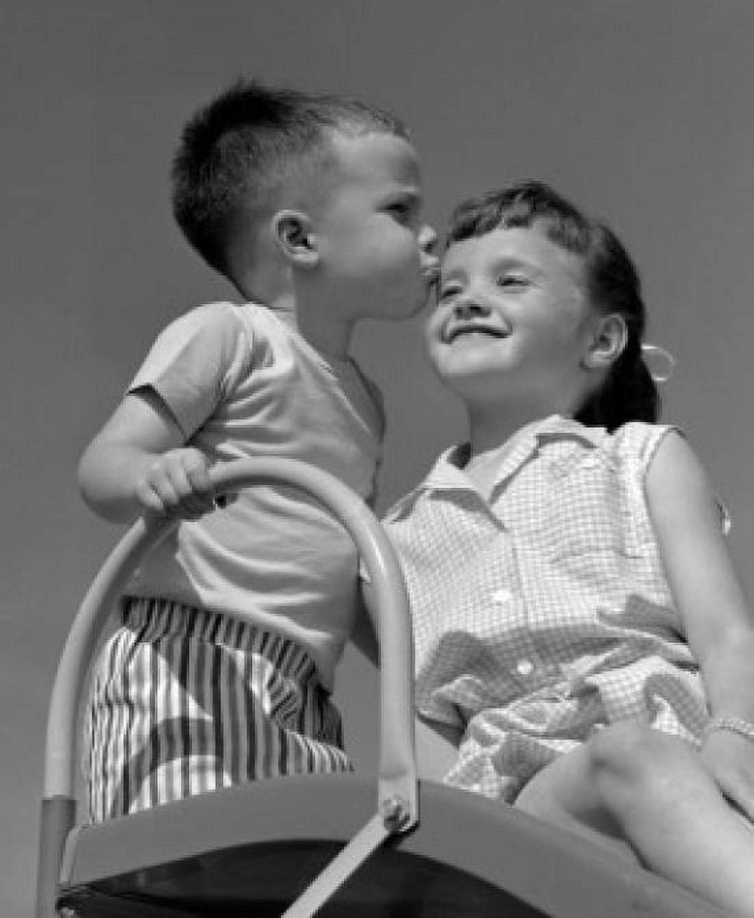 Vintage photograph of boy kissing girl on top of slide Canvas Art - (24 x 36)