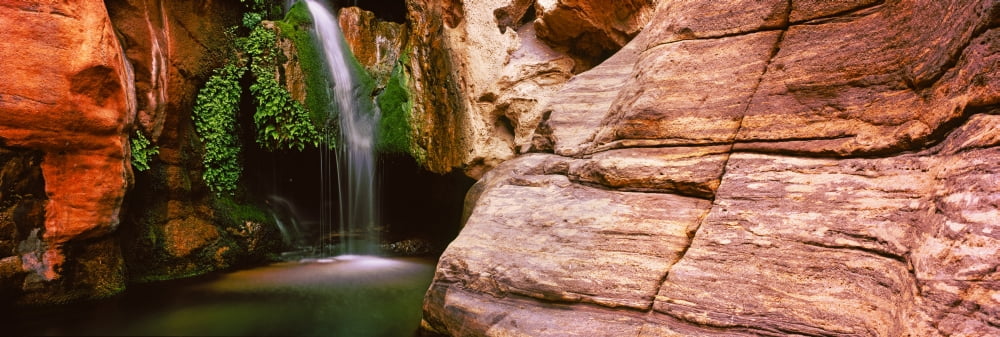 Waterfall rushing through the rocks Redwall Cavern Grand Canyon National Park Arizona USA Canvas Art - Panoramic Images (36 x 12)