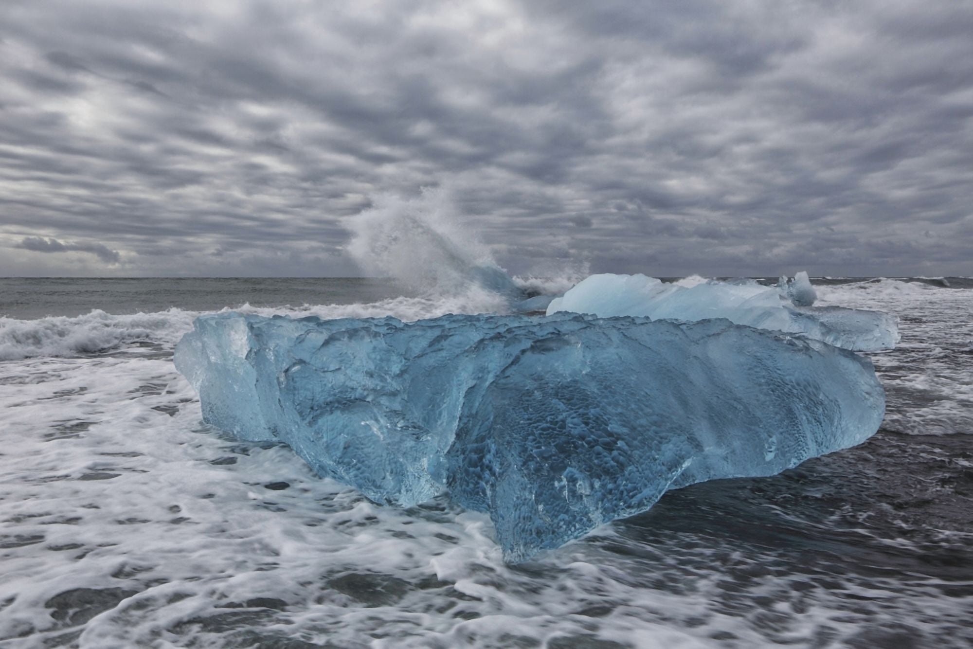 Waves from the atlantic ocean crash into ice calf from breioamerkurjokull a glacial tongue of the vatnajokull ice cap iceland Canvas Art - Robert Postma Design Pics (19 x 12)