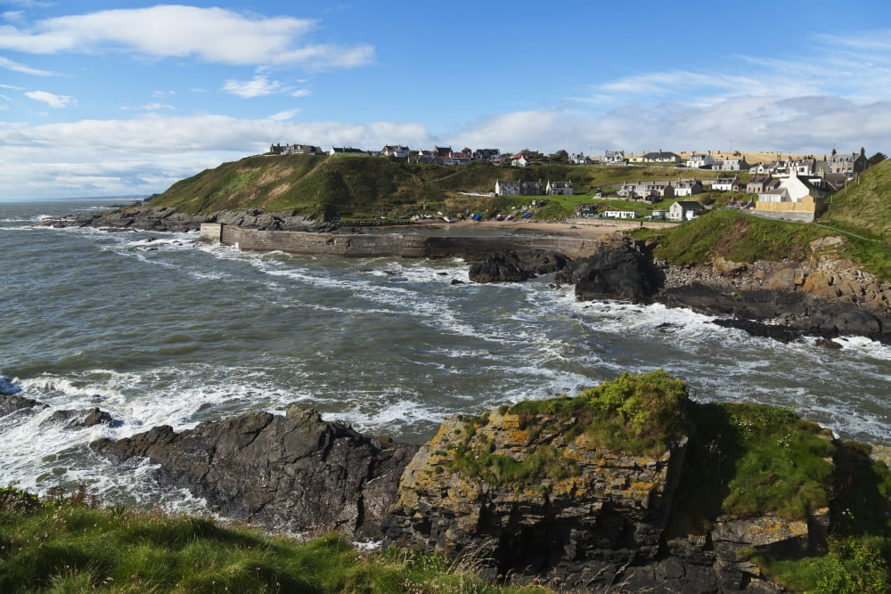 Waves crashing along the coast with buildings in the town of Grampian Grampian Scotland Canvas Art - Carl Bruemmer Design Pics (19 x 12)